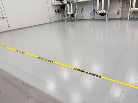 Smooth light gray epoxy floor coating in a commercial workspace
