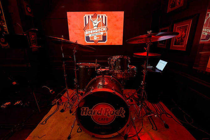 Drum kit with Hard Rock logo on a stage with red lighting – Instrument ready for a live rock concert.