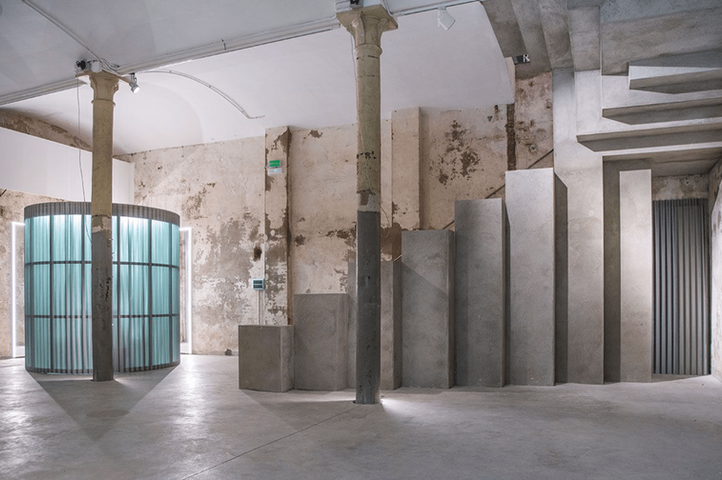 Escalera de cemento en loft industrial: Amplia escalera de hormigón con columnas antiguas en un espacio abierto de estilo industrial.
