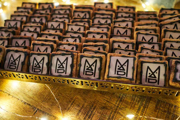 Personalized cookies with logo on a table decorated for a Christmas corporate event.