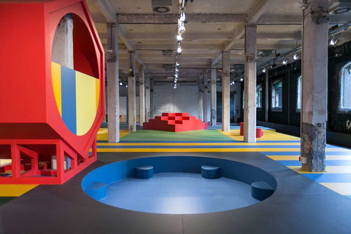Espacio interior colorido con diseño moderno y elementos geométricos, un lugar innovador para dinámicas de grupo y team building.
