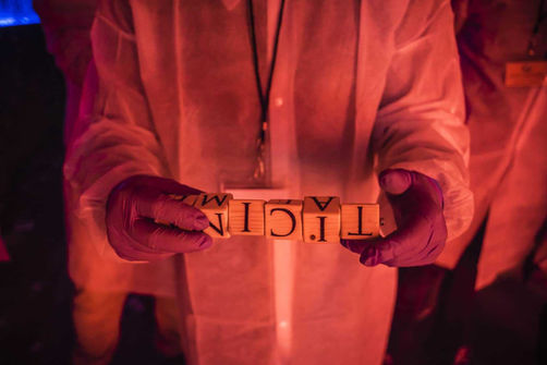 Participant holding a piece with the word "Italy". Part of a game of clues or puzzles in a group experience.