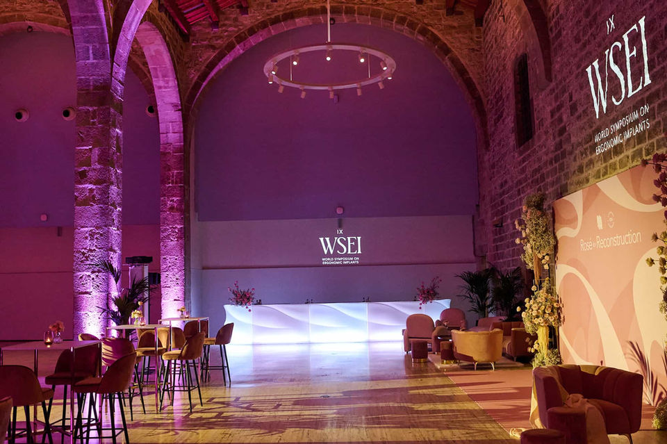 Salón de eventos con iluminación tenue y pantalla WSEI en el fondo – Espacio de conferencias con diseño sofisticado.
