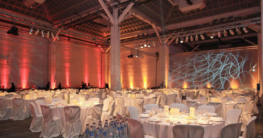 Montaje de banquete en Fira Barcelona con iluminación ambiental y diseño escenográfico para eventos empresariales exclusivos y presentaciones. Espacios para eventos de lujo en Fira Barcelona, alquiler de venues para cenas de gala, congresos y convenciones en Barcelona.