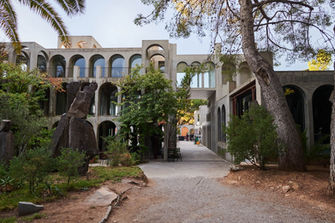 Jardín con arquitectura contemporánea rodeado de árboles y senderos – Espacio verde con estructuras modernas en un entorno natural.