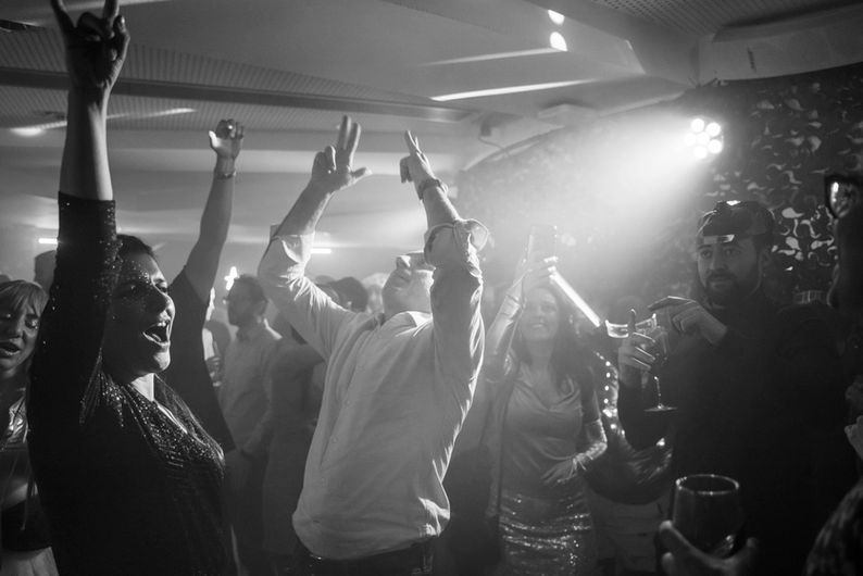 Grupo de asistentes bailando bajo luces estroboscópicas en evento inmersivo para empresas, creando un ambiente vibrante.
