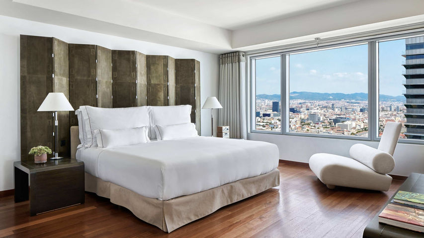 Suite moderna en el Hotel Arts Barcelona, con diseño elegante y vistas impresionantes de la ciudad y el mar. Suites de lujo en Barcelona, alojamiento premium en el Hotel Arts, experiencias exclusivas frente al mar.