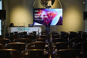 Evento corporativo "Level Up with Yealink" – Sala preparada con pantallas digitales y sillas alineadas para una conferencia VIP organizada por Yealink y Microsoft.