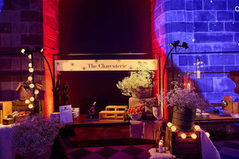 Estación de comida rústica decorada con luces y elementos naturales, creando un ambiente cálido y acogedor.