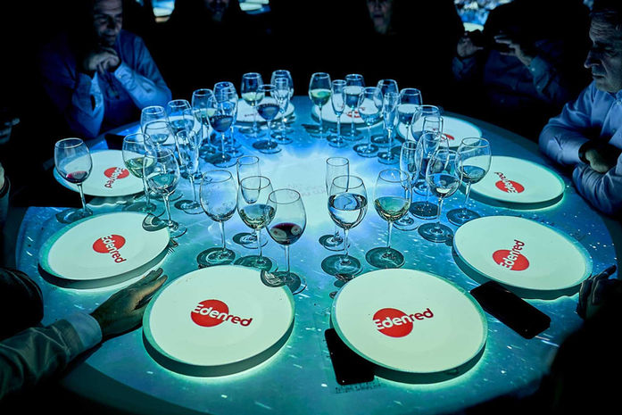 Montaje de mesa con múltiples copas y platos personalizados con logo "Zedred" – Cena corporativa con branding en la vajilla y cristalería refinada.