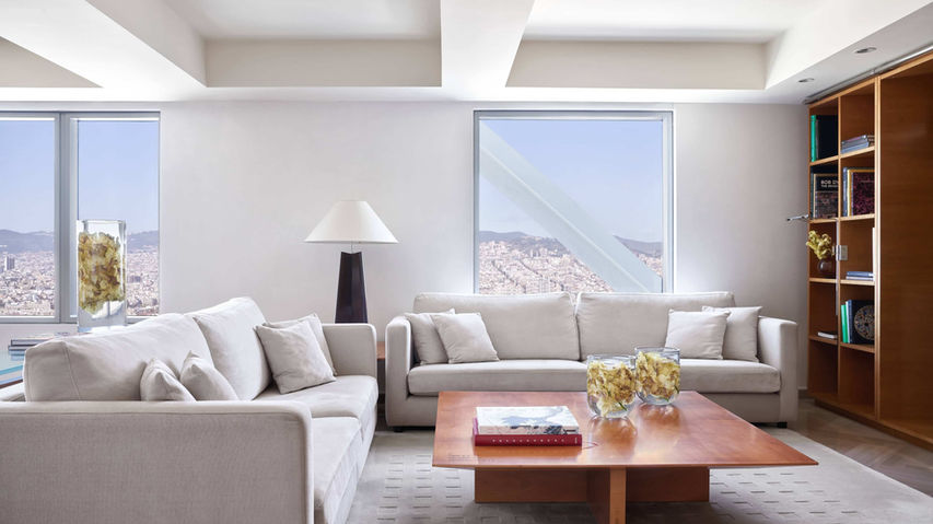 Sala de estar en una suite del Hotel Arts Barcelona, con decoración minimalista y vistas al mar. Suites con vistas en Barcelona, lujo y confort en el Hotel Arts, alojamiento de alta gama.