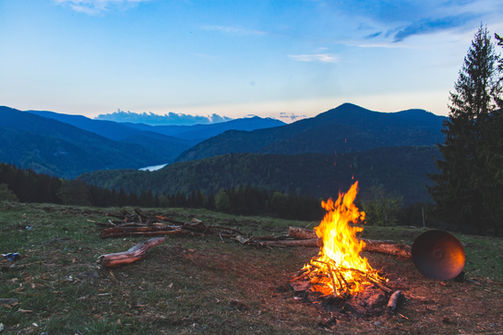 Campamento corporativo en la montaña, con una fogata y actividades de desconexión y convivencia.