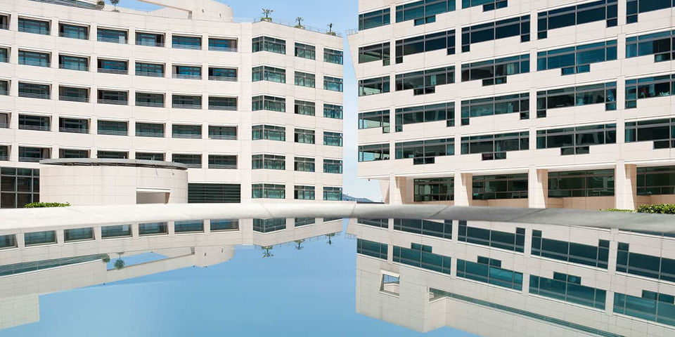 Fachada moderna del World Trade Center Barcelona con su arquitectura vanguardista reflejada en el agua, ofreciendo un entorno exclusivo para eventos empresariales y networking. Espacios para eventos en WTC Barcelona, arquitectura empresarial, venues premium en Barcelona.