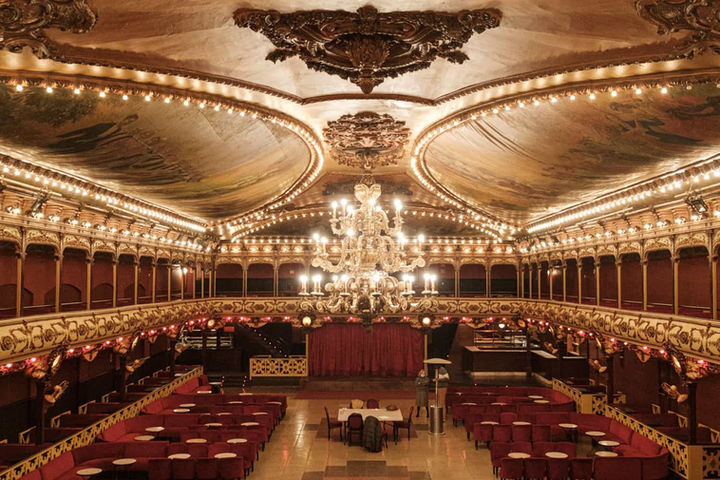 Vista panorámica de La Paloma lista para evento empresarial – Disposición de mesas, lámparas de araña y detalles ornamentales para una velada corporativa o gala.
