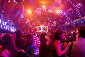 Ambiente de fiesta corporativa con asistentes disfrutando de una noche llena de música y luces.
