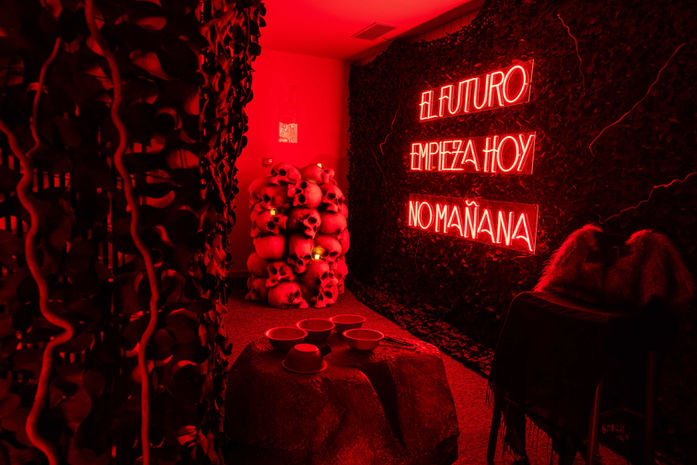 Letrero de neón rojo con la frase "EL FUTURO EMPIEZA HOY, NO MAÑANA" en una sala oscura.