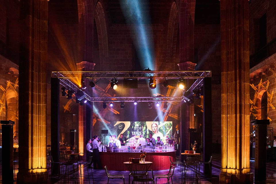 Escenario iluminado con luces de neón y DJ en un evento nocturno – Fiesta exclusiva con música en vivo y ambiente vibrante.