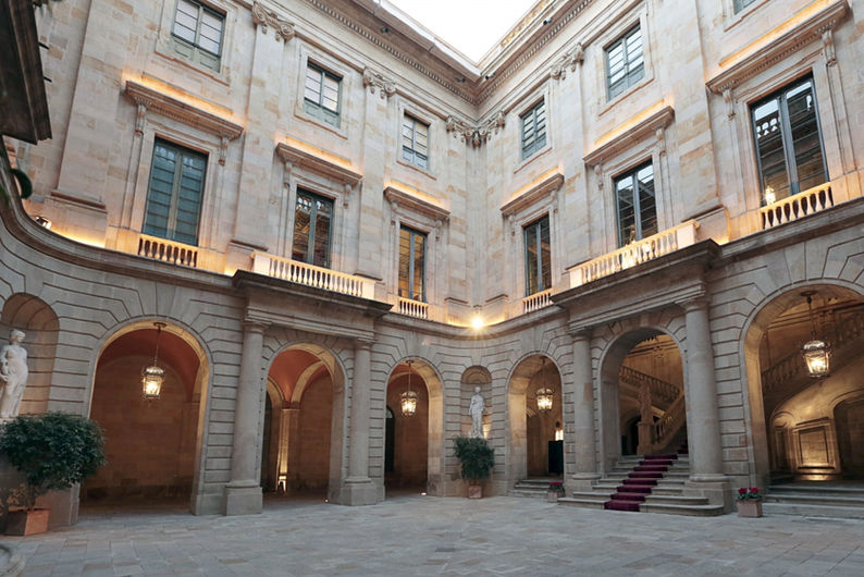 Claustro con columnas de piedra en venue para eventos empresariales y convenciones, ideal para reuniones exclusivas.
