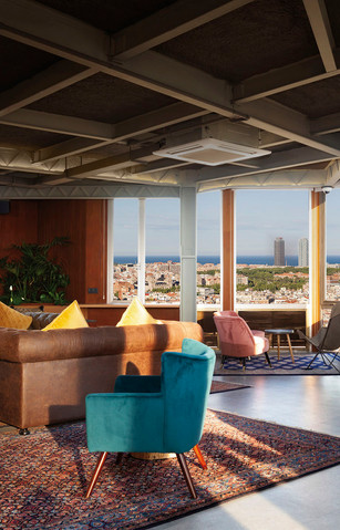 Salón con sofás de colores y vista urbana: Espacio relajante con sofás modernos, cojines decorativos y un ventanal amplio con luz natural.
