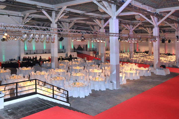 Gran evento corporativo en Fira Barcelona con alfombra roja y montaje de mesas para banquetes, ideal para galas y celebraciones de empresa. Eventos empresariales en Fira Barcelona, cenas de gala y conferencias, alquiler de espacios para grandes celebraciones.