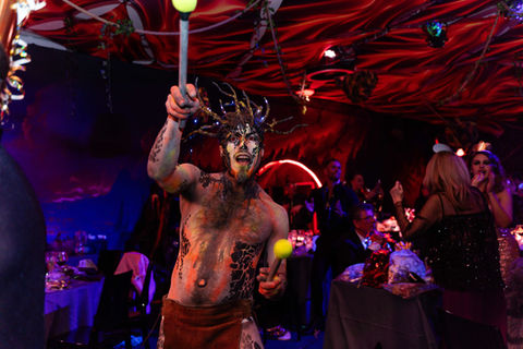 Hombre con pintura corporal tribal animando una fiesta temática para empresas, destacando la ambientación exótica.