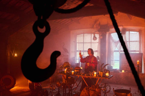 Decoración temática con ganchos metálicos y ambiente de suspenso – Escenografía de terror con iluminación oscura y detalles misteriosos.