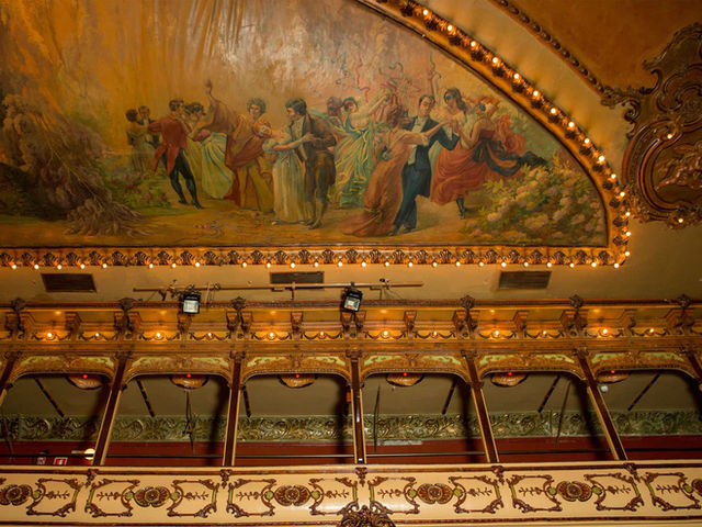 Detalles artísticos en el techo de La Paloma Barcelona – Fresco pintado con escenas clásicas y molduras doradas que resaltan la riqueza arquitectónica del espacio.
