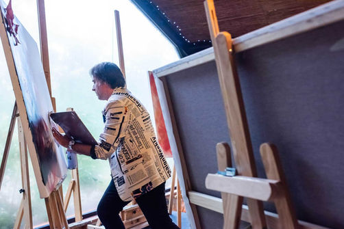 Participant in an outdoor painting workshop, exploring creativity and teamwork at corporate events.