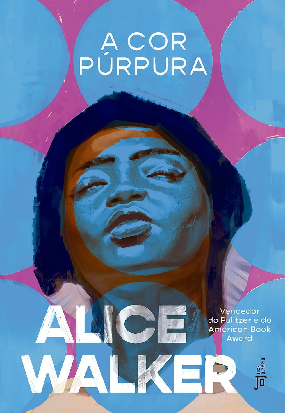 Capa do livro A Cor Púrpura, de Alice Walker. A imagem mostra o rosto de uma mulher negra em tons artísticos de azul e roxo, olhando para frente. O fundo é rosa com grandes círculos azuis. No topo está escrito “A Cor Púrpura” e na parte inferior o nome da autora, Alice Walker. A capa também informa que o livro foi vencedor do Prêmio Pulitzer e do American Book Award.