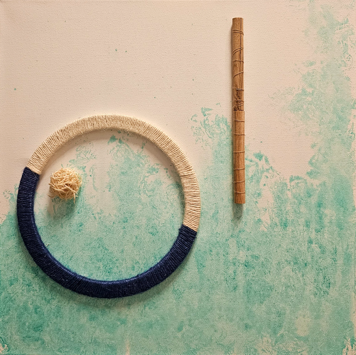 Abstract mixed-media artwork on a pale green and white background featuring a circular form wrapped partly in dark blue thread, enclosing a small natural centre, beside a vertical wooden element, suggesting an inner place of safety and grounding.