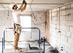 electrician-installer-with-tool-his-hands-working-with-cable-construction-site