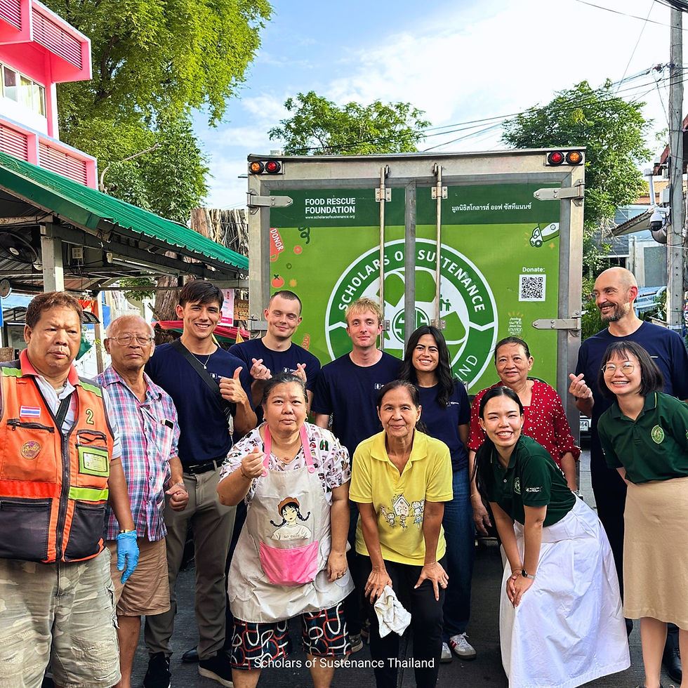 A diverse group of people smiling in front of a green food rescue truck with logo and text. Outdoor setting with trees and buildings. Joyful mood.