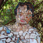 large mosaic sculpture of sitting boy