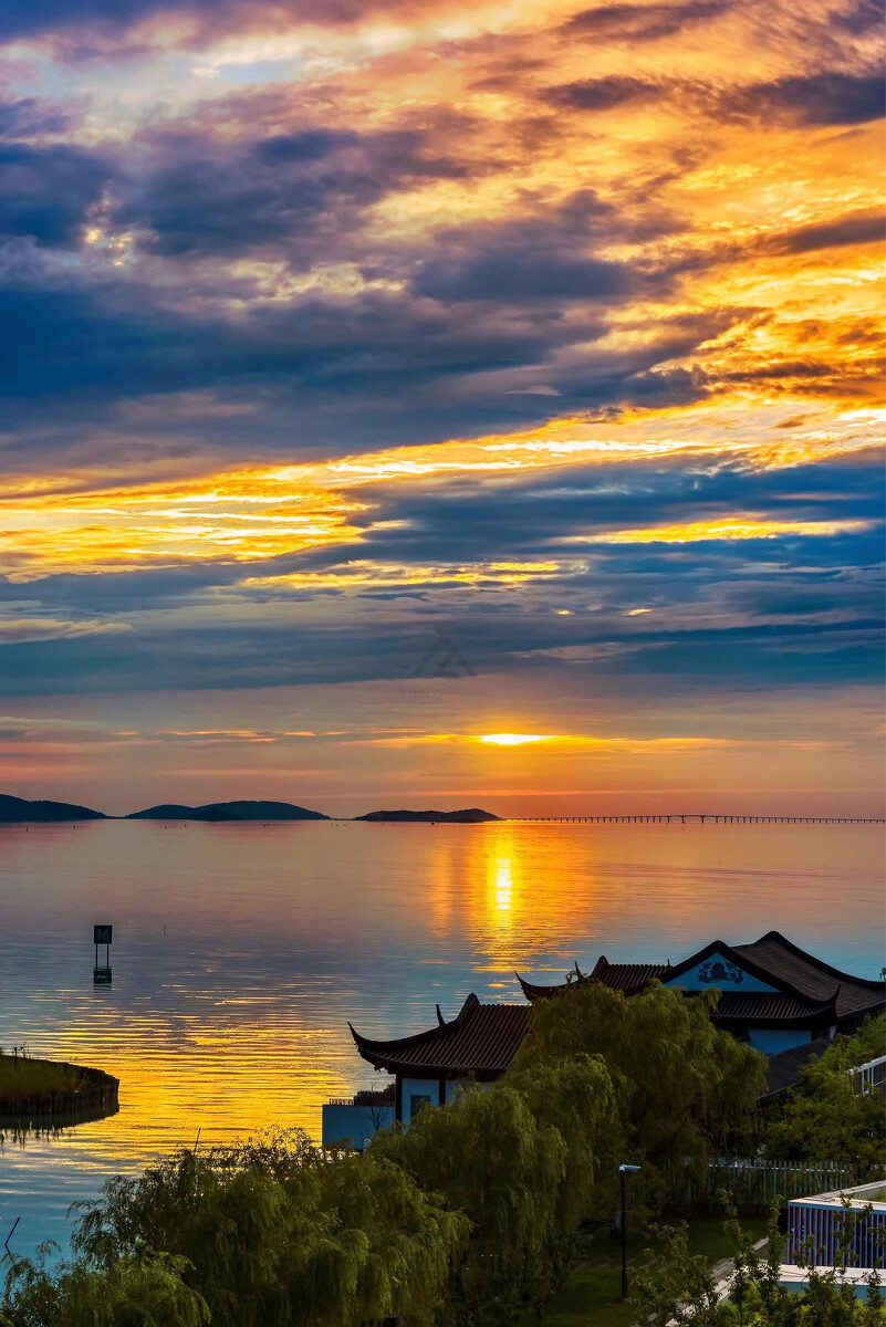 Colorful water sunset on Lake Tai, Suzhou - bridge and islands visible on the horizon.