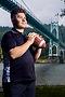 Cinematic senior football portrait at St. Johns Bridge in Portland, Oregon using directional lighting and urban structure.