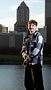 Cinematic senior portrait with Portland skyline and river in the background using directional lighting and urban composition.