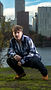 Cinematic senior portrait with Portland skyline in the background using directional lighting and urban composition.