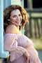 Close-up maternity portrait of a smiling woman in soft natural light in Portland, Oregon.