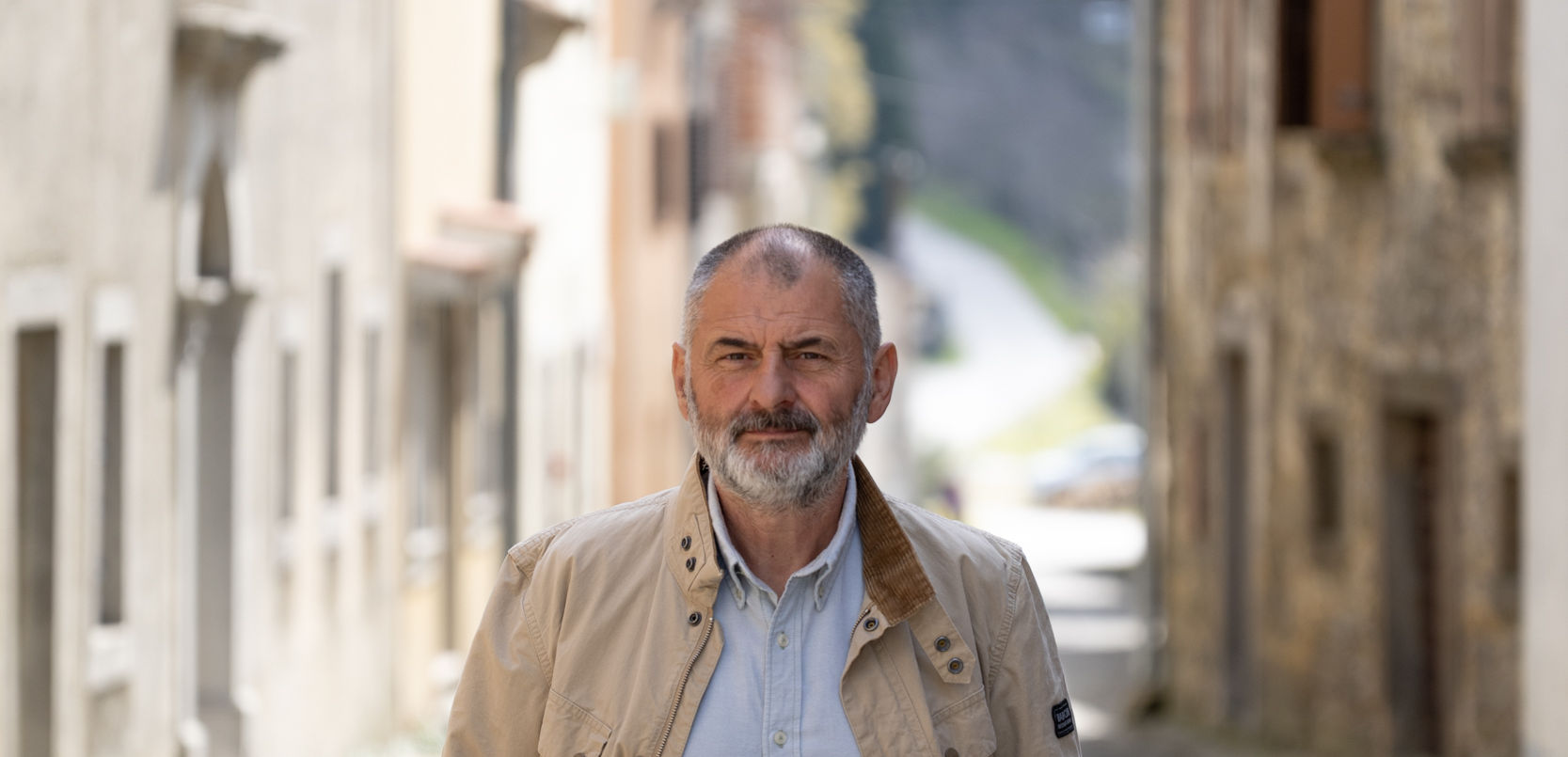 Portret čovjeka u starom Istarskom selu s nizom kuća u pozadini