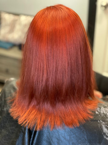 A girl with short, curly hair dyed a vibrant red