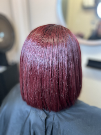 A young girl with short, vibrant red hair styled in a modern, slightly edgy cut