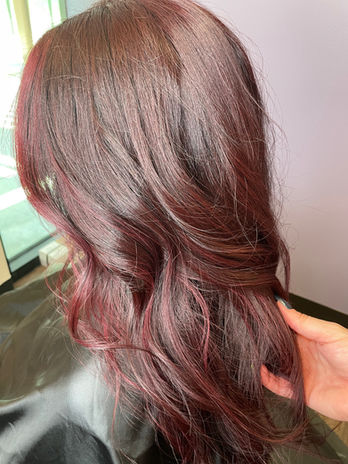 A girl with short, curly hair dyed a vibrant red.