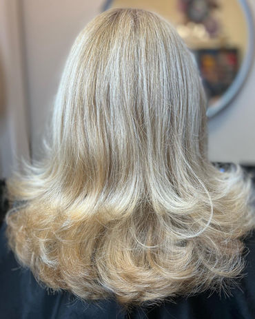 A girl with short, stylishly cut hair that is colored in a striking white-golden hue