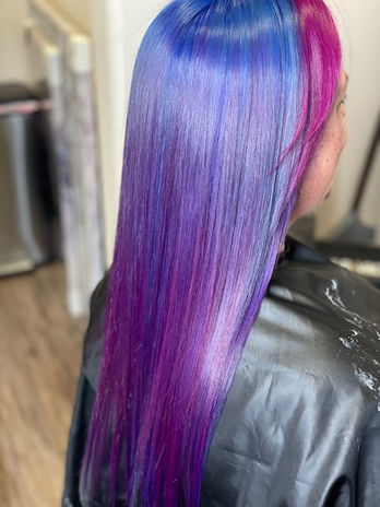 A woman with long hair showcasing a fusion of blue and purple hair colors