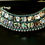 Thumbnail: A necklace made of avalon gems and green as if awarovski lines with silver covered metals.All embroidery on a black felt. The