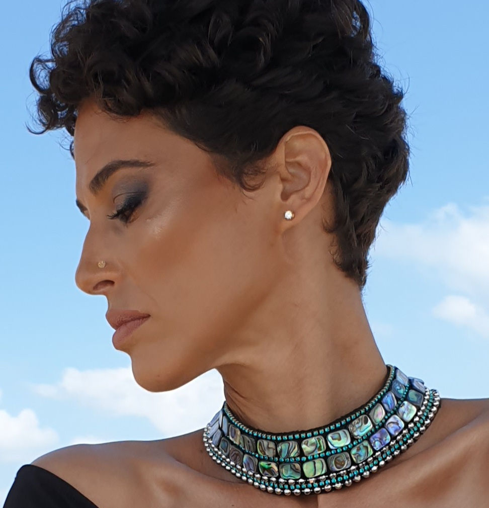 Thumbnail: A necklace made of avalon gems and green as if awarovski lines with silver covered metals.All embroidery on a black felt. The