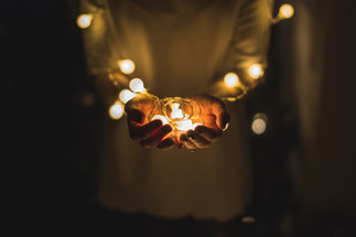 Person holds light bulbs in hands in the dark