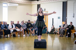 a blonde women perfr=ormer poses on a box