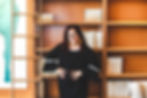 Marta Miranda-Straub in front of bookshelf.