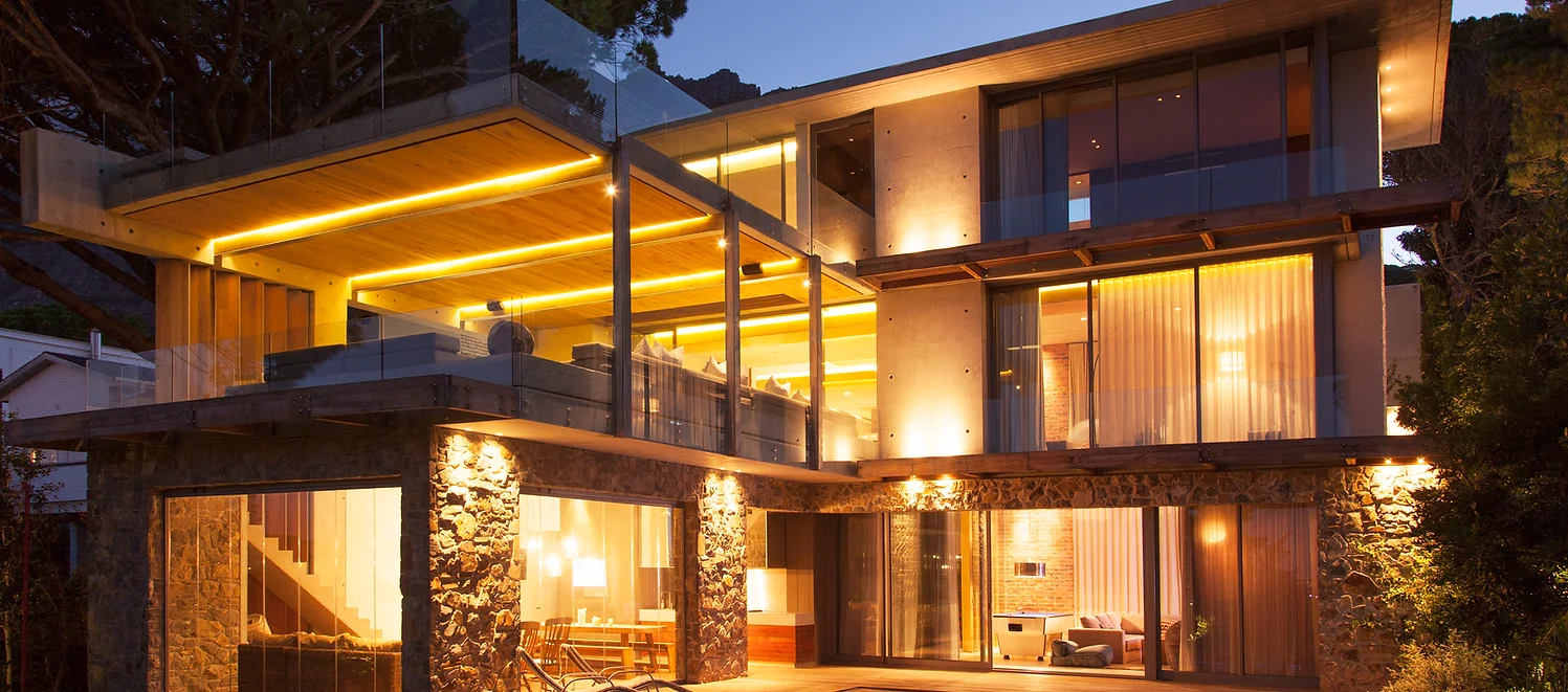 Modern home with lights on at night, photo taken from exterior.